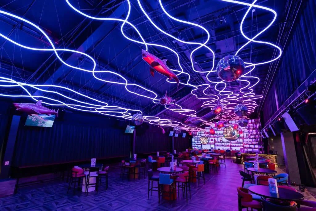 Purple RGB neon flex ceiling waves with disco ball and crystal chandelier mid-install