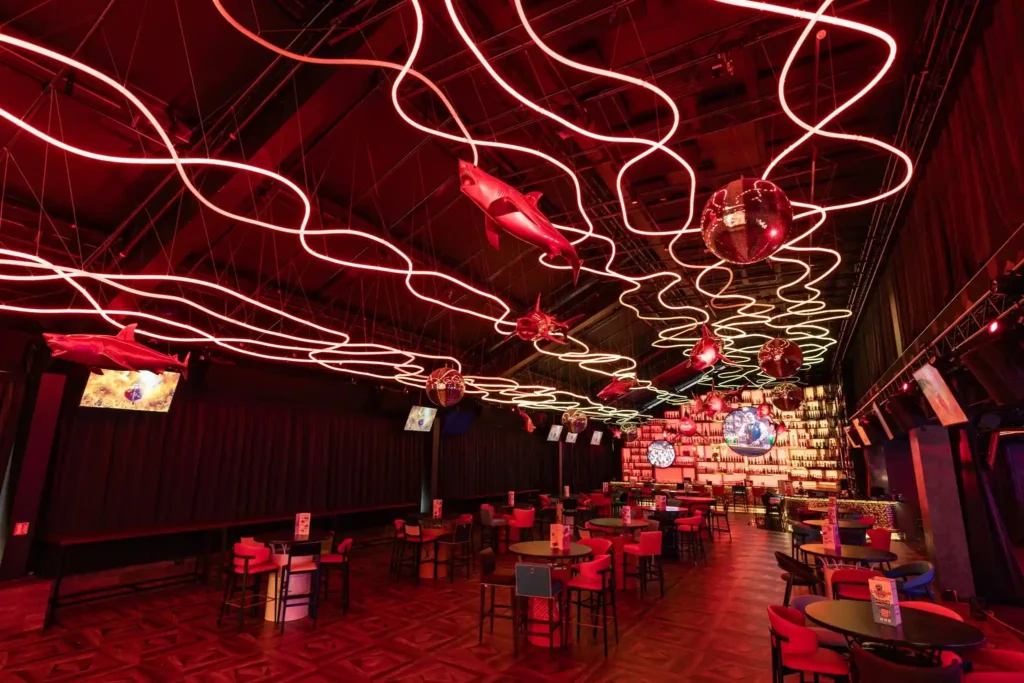Red RGB neon flex ceiling scene over themed entertainment hall in Prague