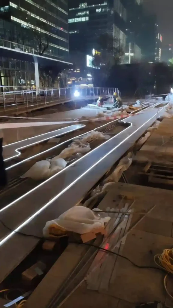 Linear LED lighting paver inlay installation on a Shenzhen CBD mall plaza at night