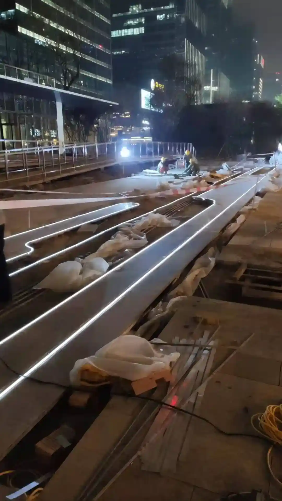 Linear LED lighting paver inlay installation on a Shenzhen CBD mall plaza at night
