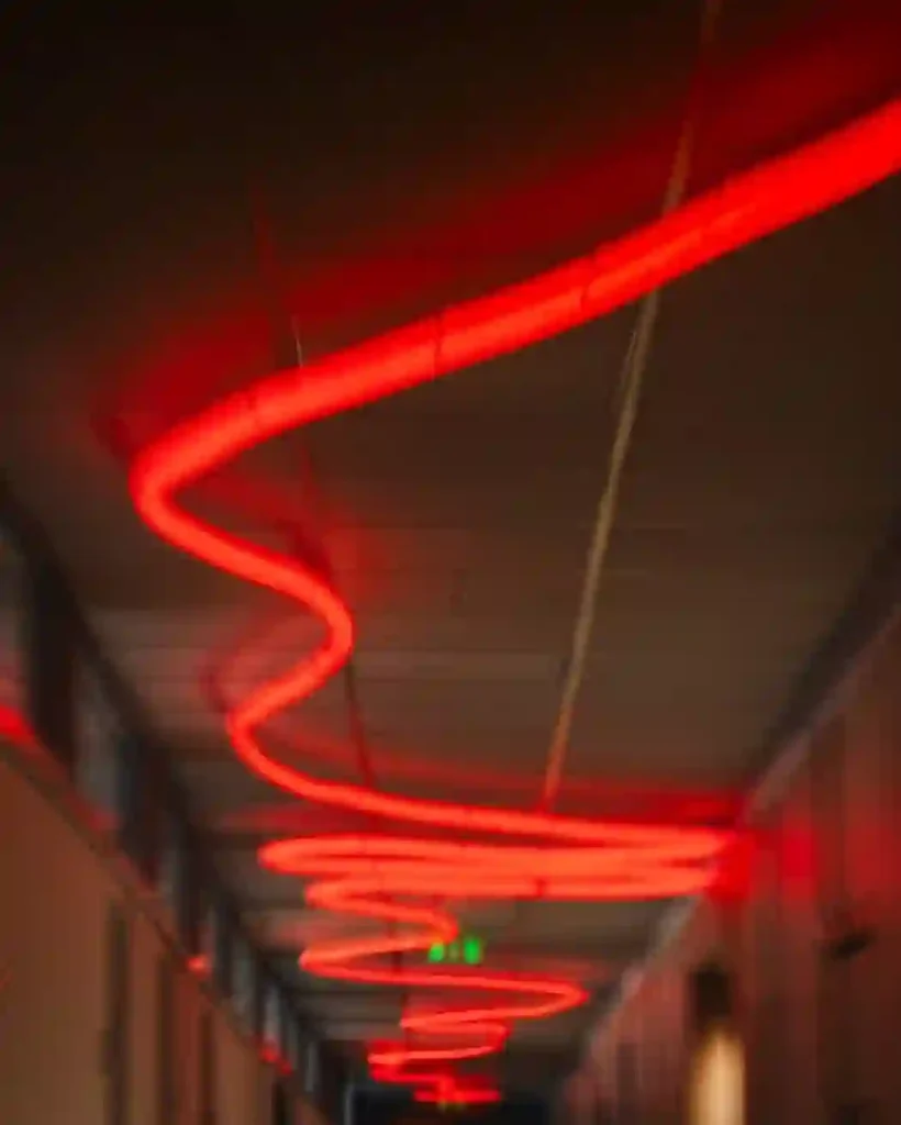 Coiled red round neon flex LED helix ceiling sculpture in office corridor