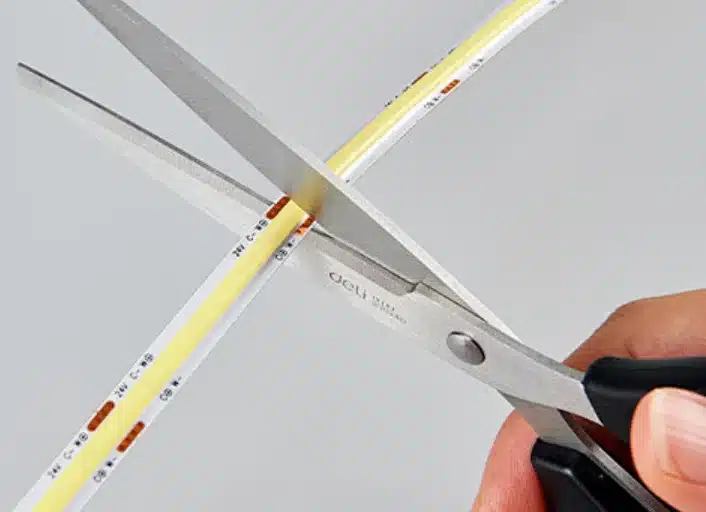 Cutting COB LED strip with scissors at the correct cut line